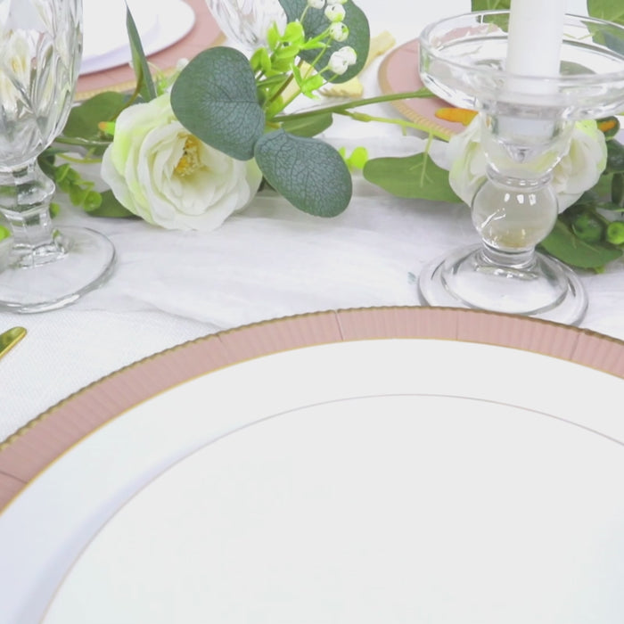 Dusty rose round dinner plate with gold rim on a decorated table setting.