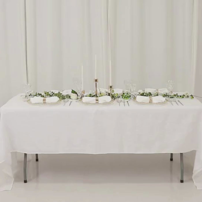 Clear acrylic charger plates with gold beaded rim on a decorated dinner table.