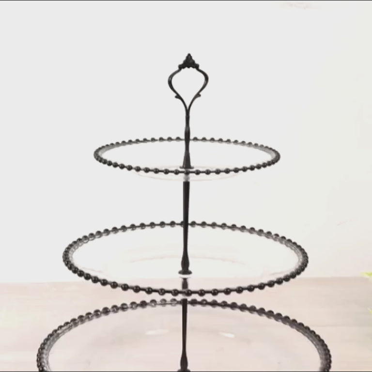 Clear 3-tier round cupcake tower stand with black beaded rim and top handle.