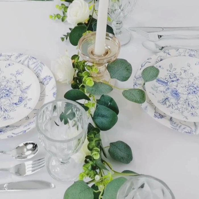 Elegant white and blue paper round dessert and dinner plates on a table setting.