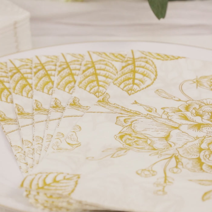 White paper cocktail napkins with gold floral pattern.