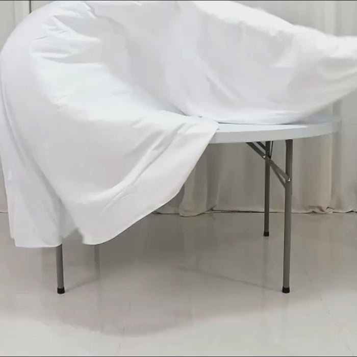 White fire retardant round tablecloth on a folding table.