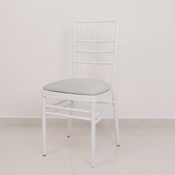 Silver chiavari chair with a fitted cushion cover in a minimalist setting.