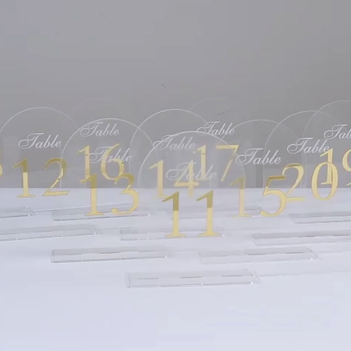 Clear arch acrylic table numbers with gold print for elegant receptions.