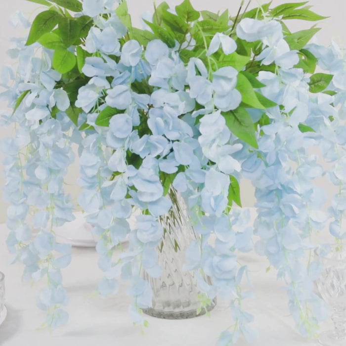 Light blue artificial silk wisteria flower garland in a decorative vase.