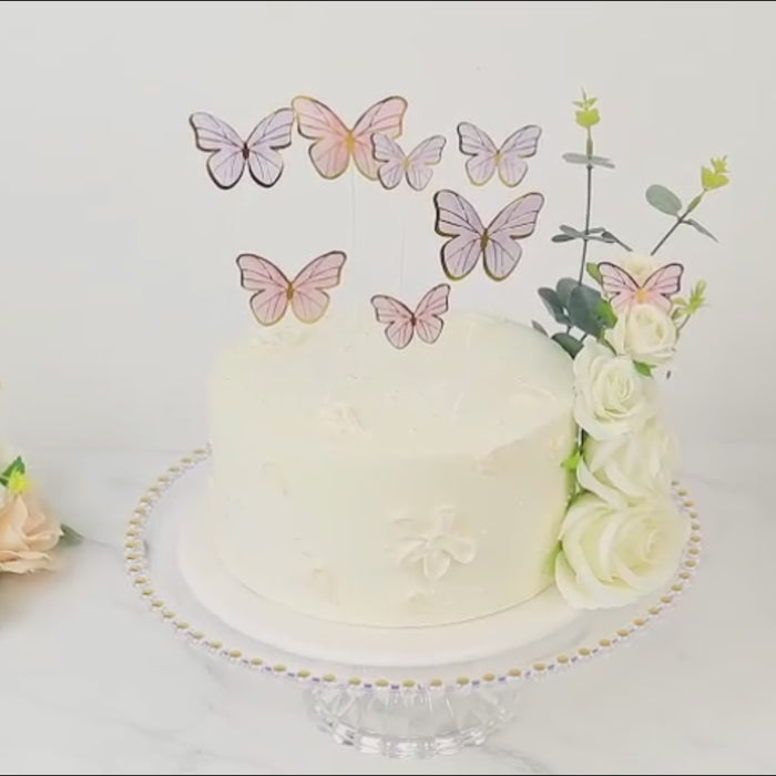 Pink 3D butterfly cake toppers with gold edges for decoration.