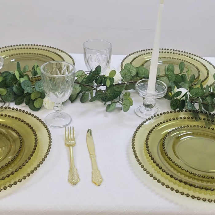 Dusty sage green charger plates with beaded rim on a dining table setting.