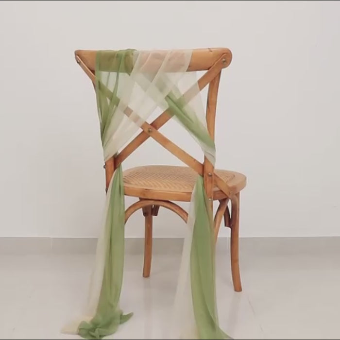 Sheer chair sash in dusty sage green beige draped on a wooden chair.