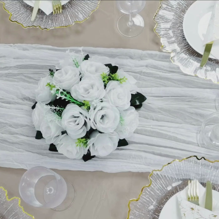 White gauze cheesecloth table runner with floral centerpiece on a banquet table.