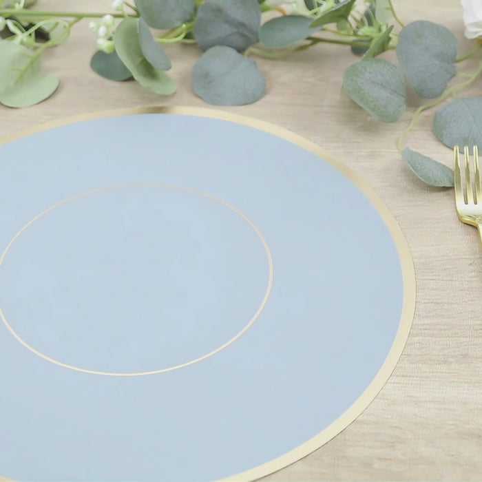 Dusty blue round placemat with gold rim on a wooden table setting.
