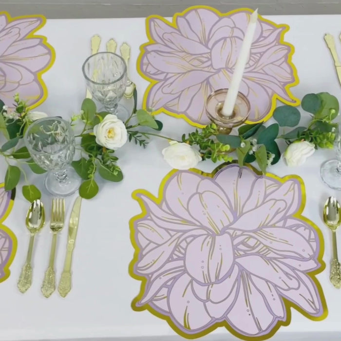 Lavender peony flower print placemats with gold foil edges on a table setting.