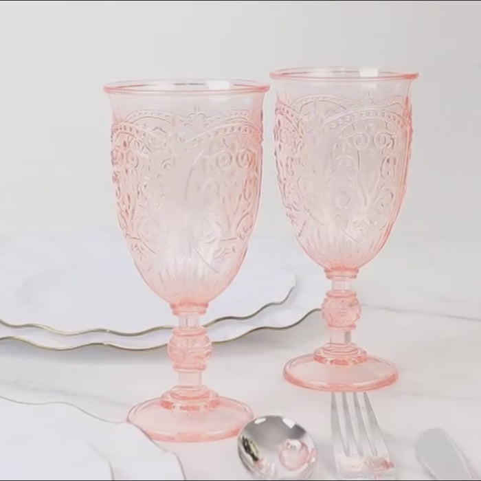 Transparent blush vintage goblets on a marble surface.