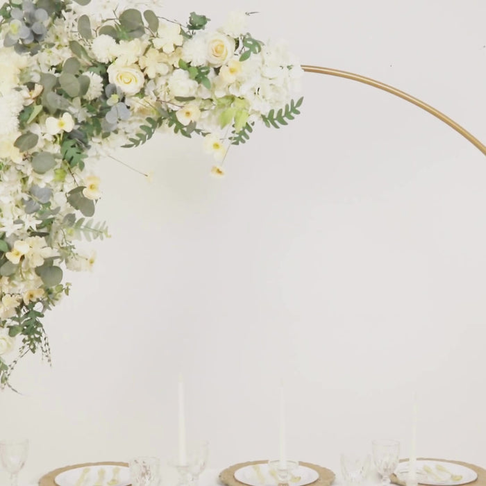 Gold metal balloon arch stand adorned with white flowers for wedding decor.