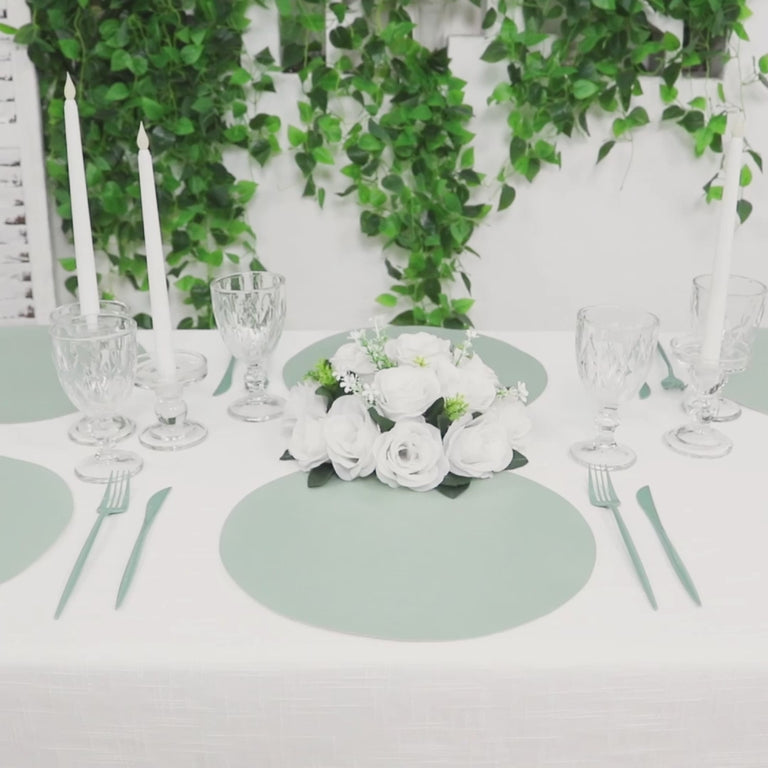 Sage green disposable paper placemats on a dining table setting.