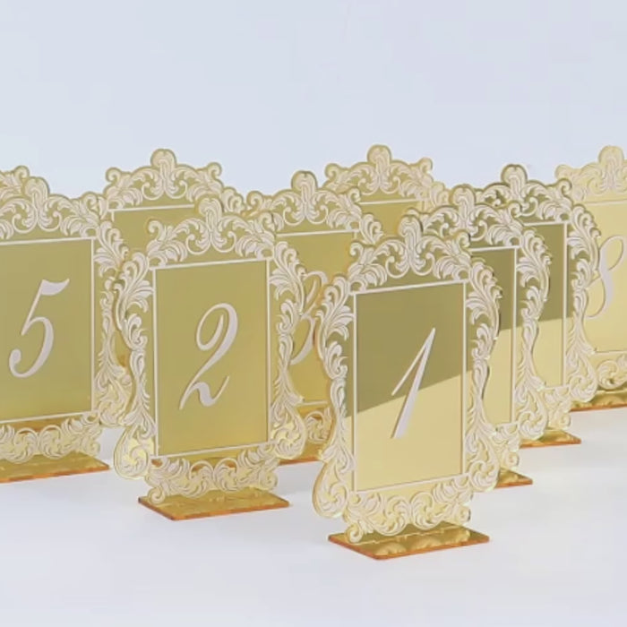Gold mirror table numbers with Baroque lace border for elegant receptions.