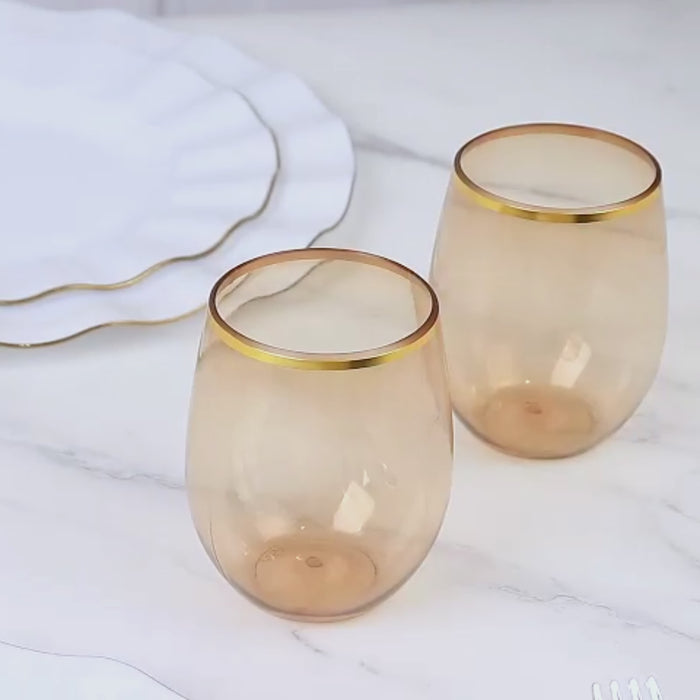 Transparent amber stemless wine glasses with gold rim.