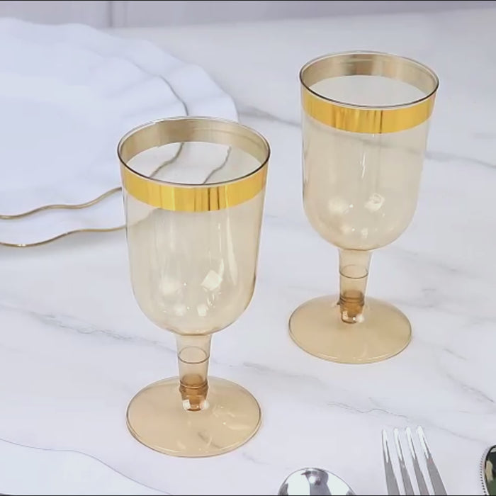 Transparent gold short stem wine glasses with gold rim.
