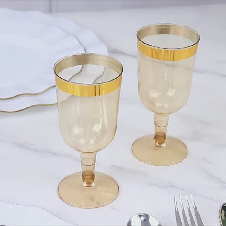Transparent gold short stem wine glasses with gold rim.