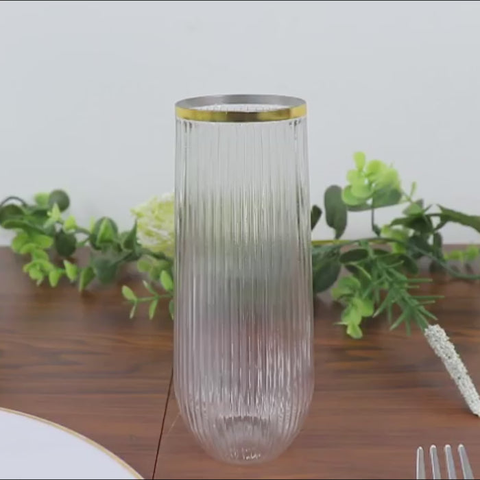 Clear stemless champagne flute with a gold rim and ribbed design.