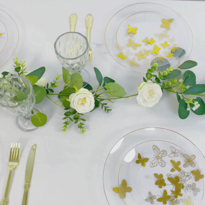 Clear plates with gold butterfly design and gold rim on a white table setting.