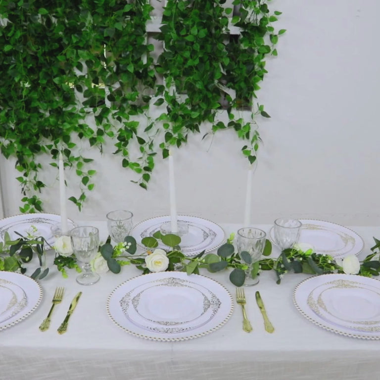White charger plates with gold beaded rim on an elegantly set dinner table.