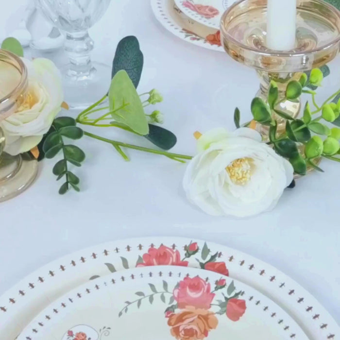 Ivory round dessert plates with floral design on a table setting.