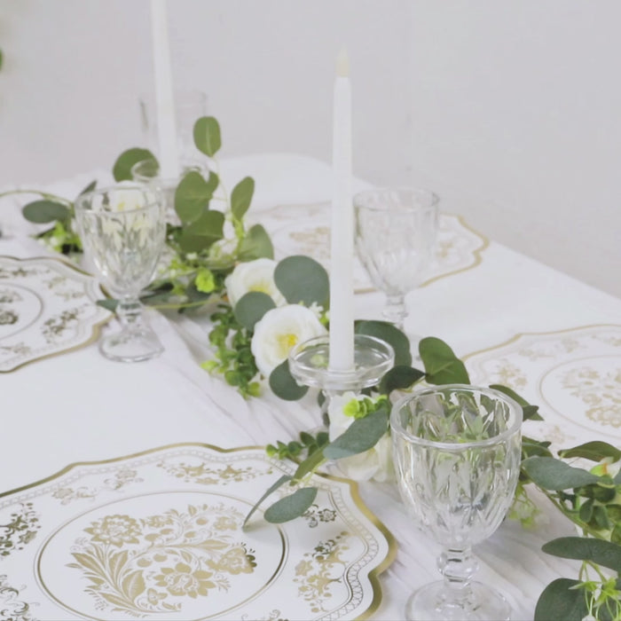 White and gold damask floral disposable placemats on a table setting.