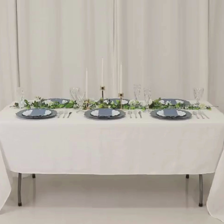 Dusty blue charger plates on a beautifully set dining table.