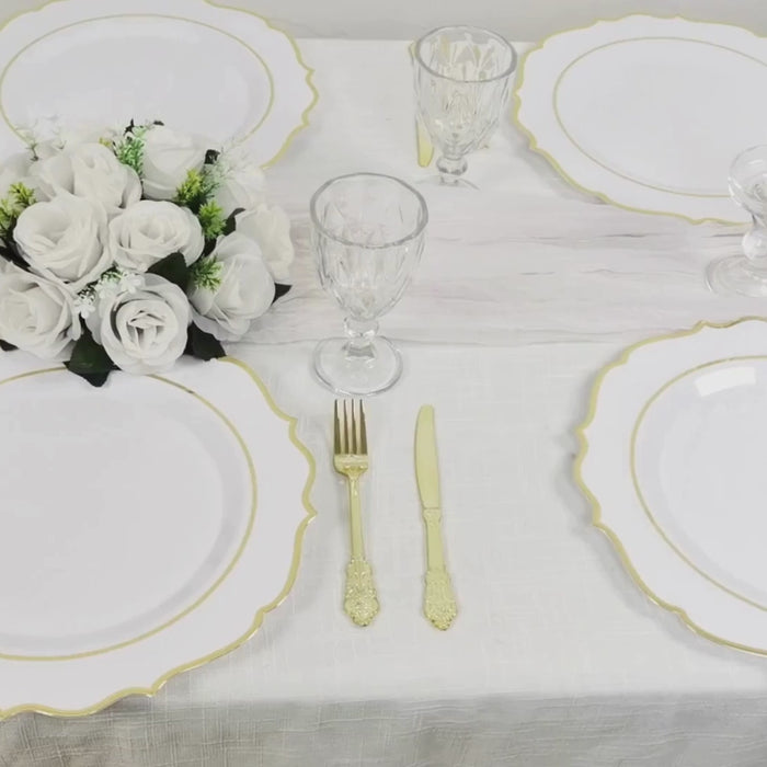 White charger plates with gold scalloped rim on a festive table setting.