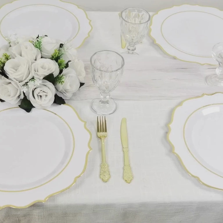 White charger plates with gold scalloped rim on a festive table setting.