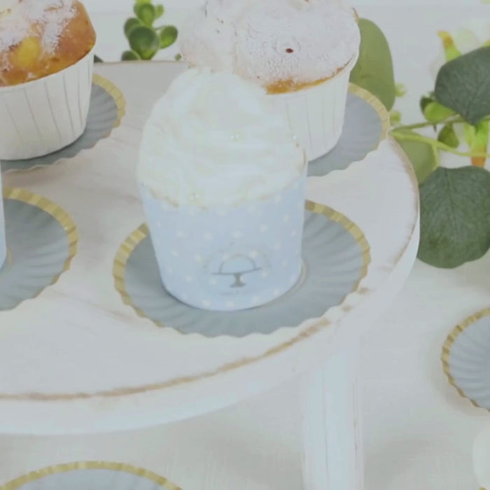 Dusty blue mini dessert plates with gold scalloped rim showcasing cupcakes.