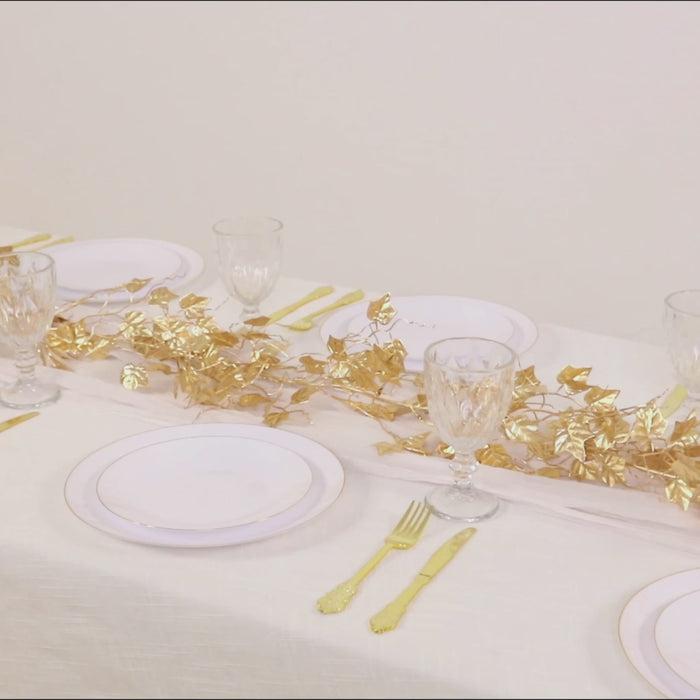 Metallic gold artificial ivy leaves garland on a dining table setting.
