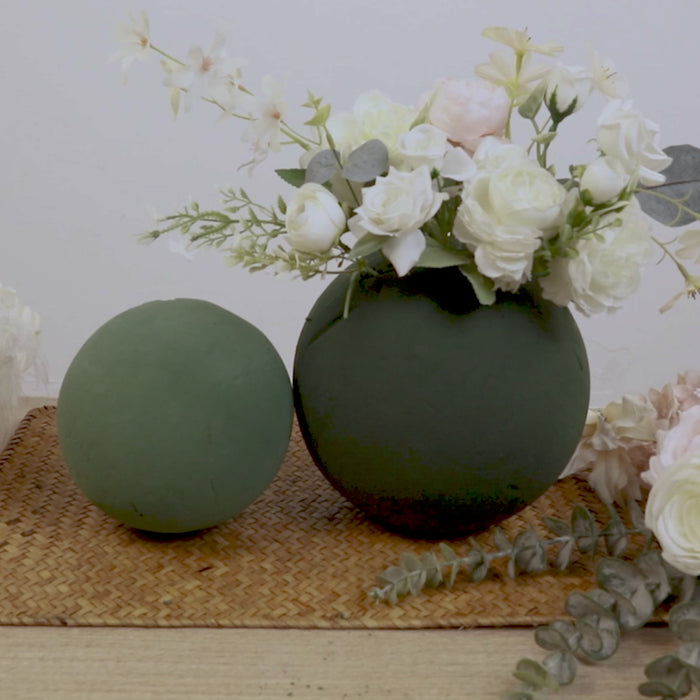 Green DIY floral foam balls with smooth surface for craft arrangements.