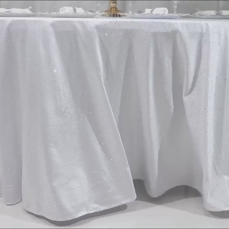 White tablecloth with rhinestone accents for luxury events.