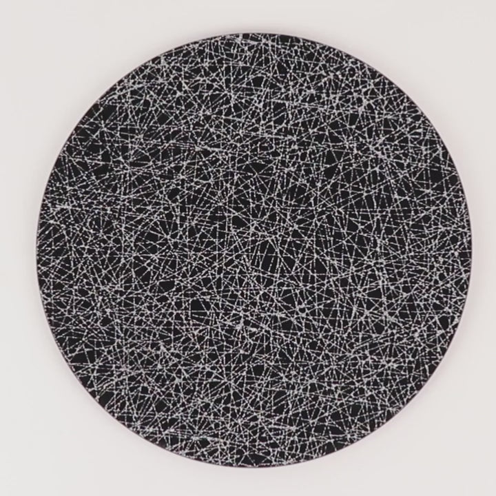 Black acrylic charger plate with glitter silver abstract lines pattern.