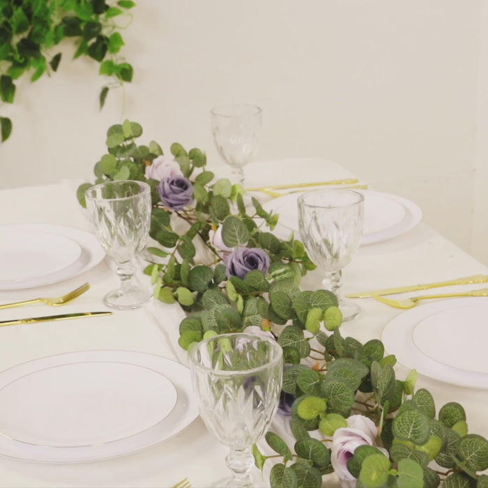 Artificial eucalyptus garland with lilac silk roses on a table setting.