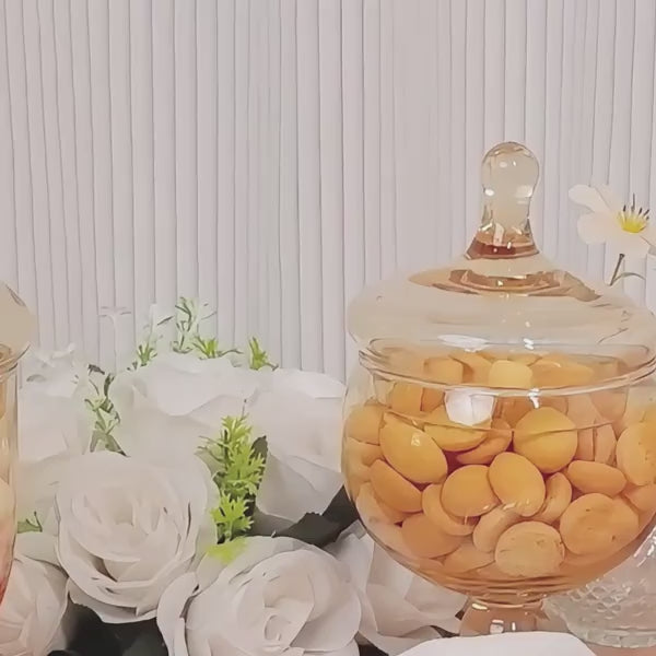 Amber gold glass jars with snap-on lids filled with candy.