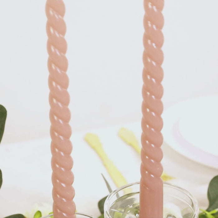 Dusty rose spiral taper candles in a 12-pack, perfect for dinner settings.