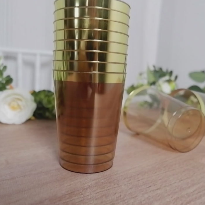 Amber gold disposable tumbler cups with gold rim, perfect for parties.