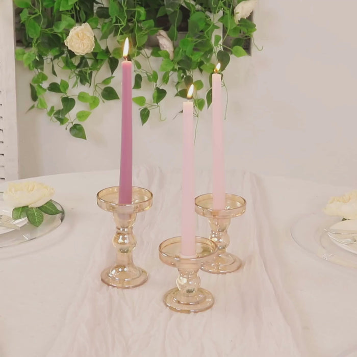 Amber gold glass candle holders with pink and purple candles.