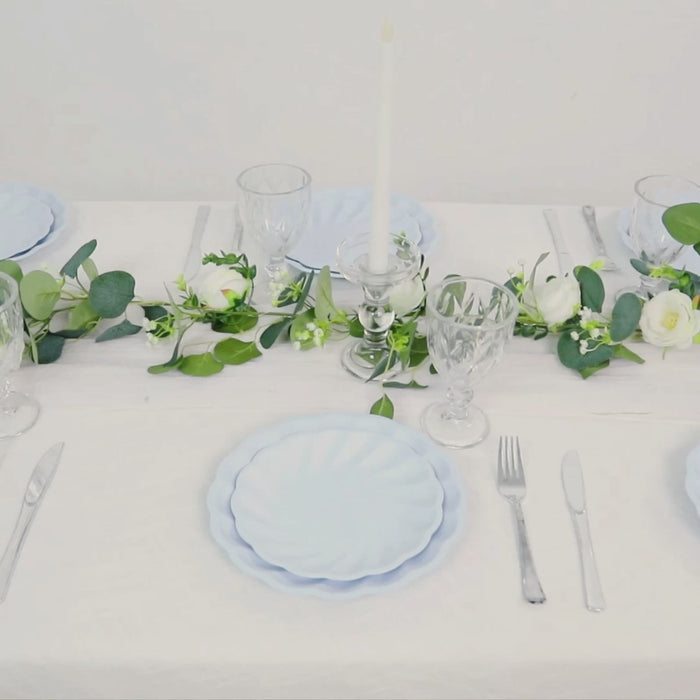 Light blue swirl scalloped compostable dinner plates on a decorated table.