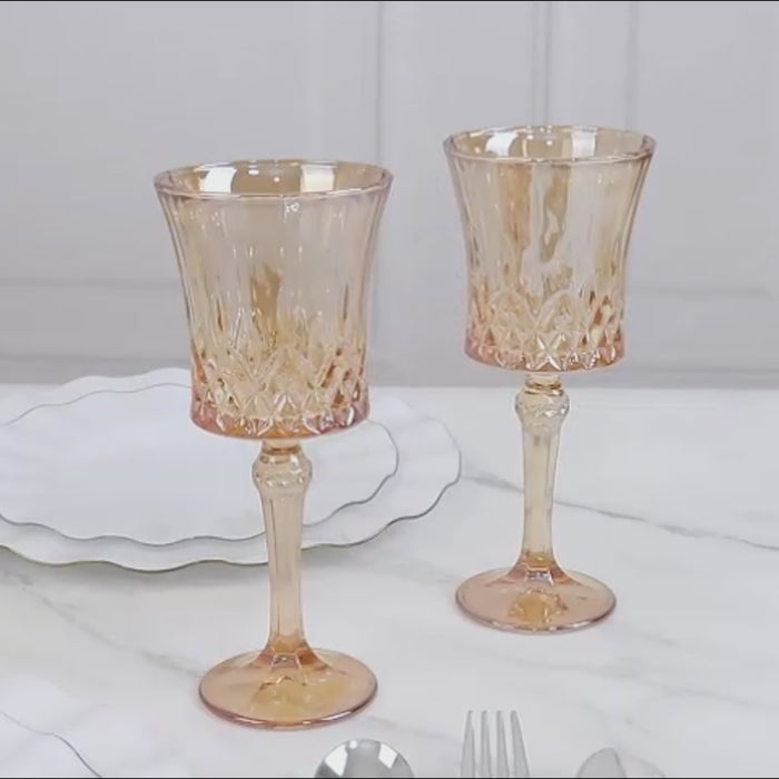 Amber gold crystal cut glass goblets on a marble table setting.