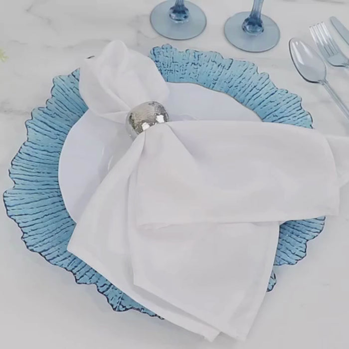 Dusty blue charger plate with textured reef design on a table setting.