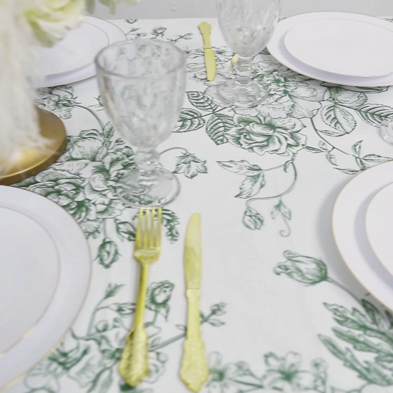 White tablecloth with sage green French toile pattern, perfect for dining.