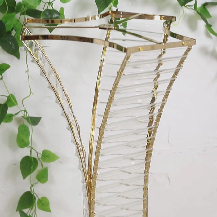 Gold metal hourglass vase holder for floral arrangements.