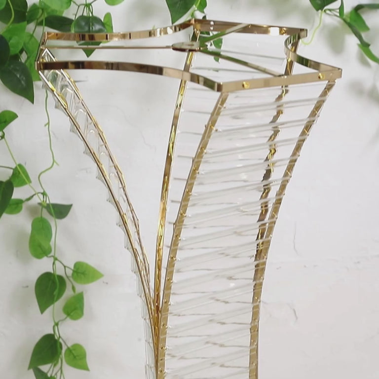 Gold metal hourglass vase holder for floral arrangements.