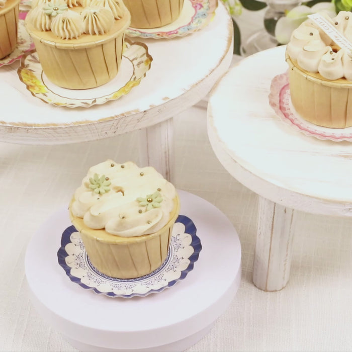 Vintage floral mini plates with desserts on white wooden stands.