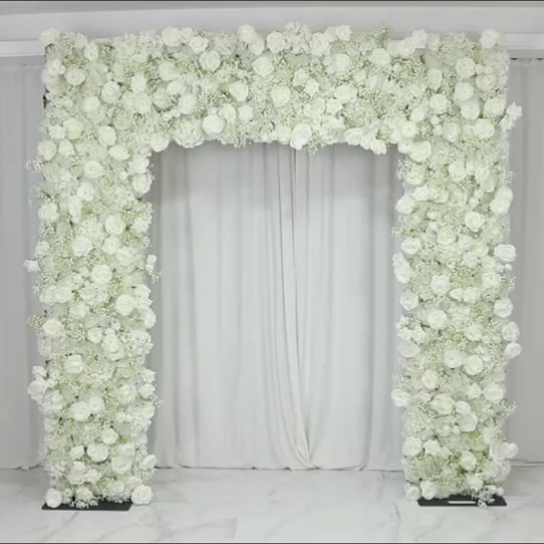 White artificial flower backdrop with silk roses and baby's breath for wedding arch.