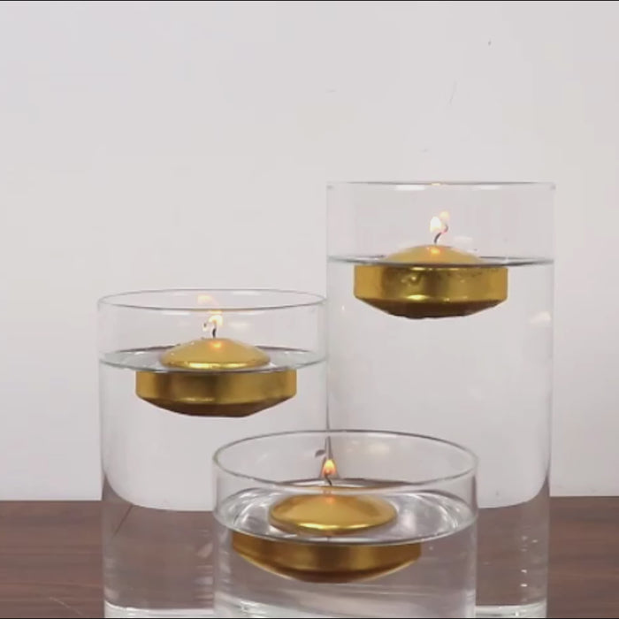 Gold floating candles in clear vases with water.