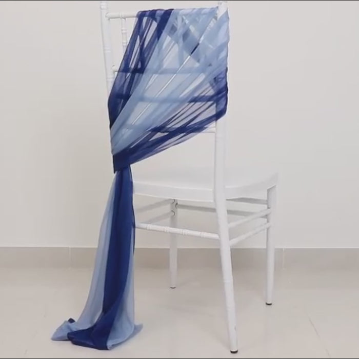 Navy blue and dusty blue sheer chair sash draped on a white chair.